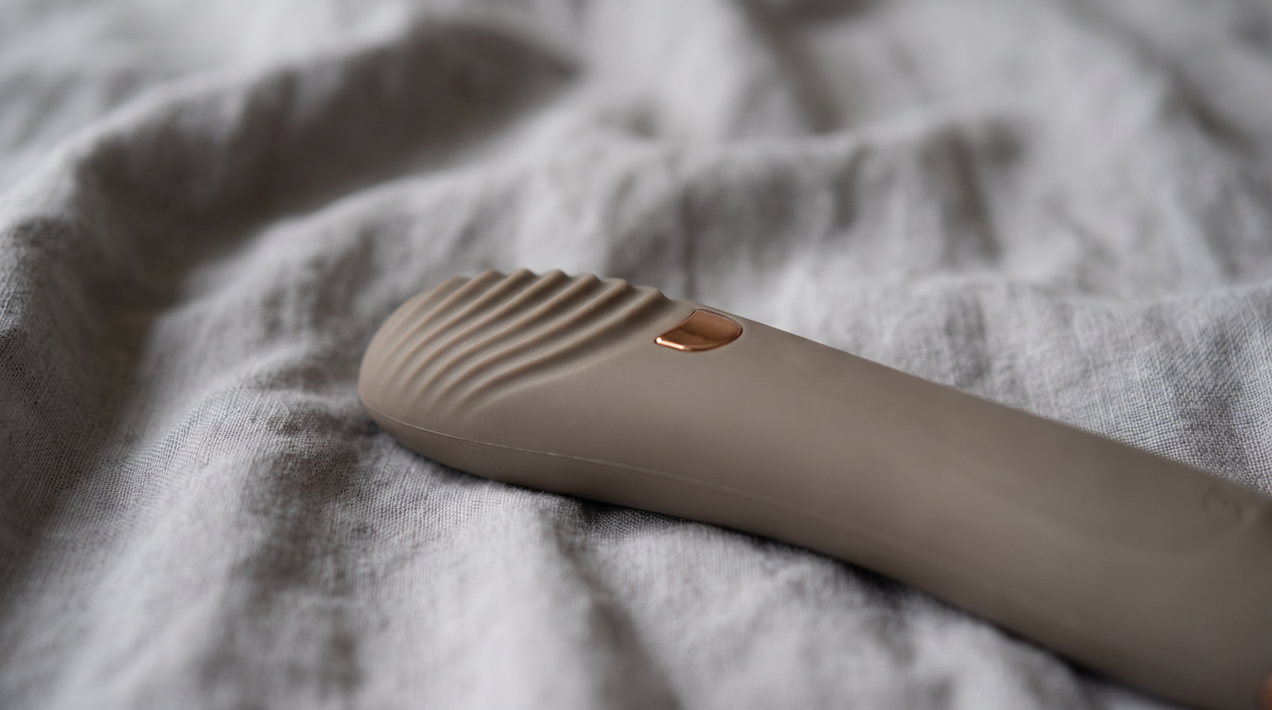 Close-up of a tongue vibrator on soft fabric